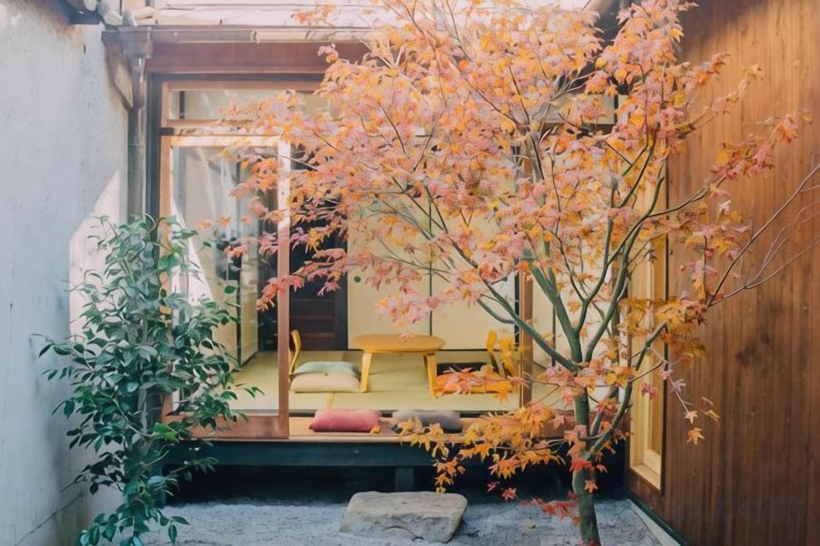 A traditional Japanese-style room with tatami flooring, a low wooden table, and a sliding door leading to a tatami room.