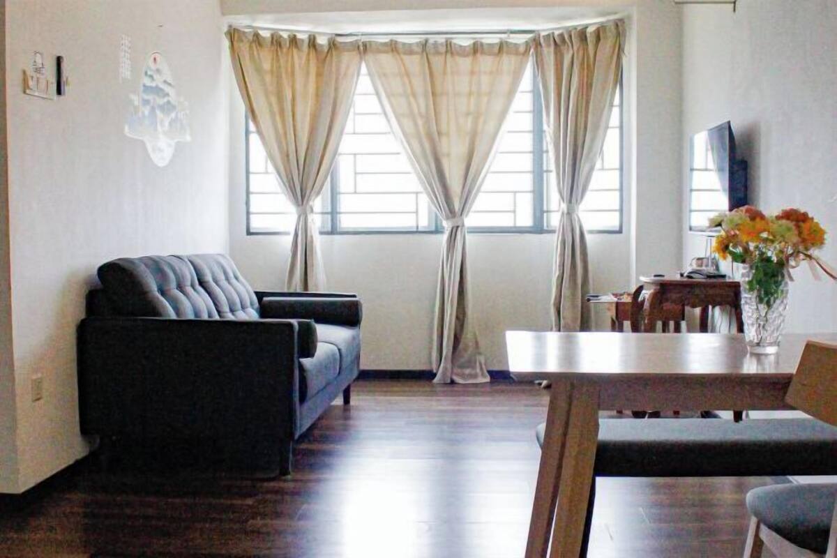 Ein Wohnzimmer mit einer Couch, einem Esstisch und einem Fernseher.