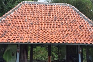 A building with a tiled roof and a covered area with a glass enclosure.