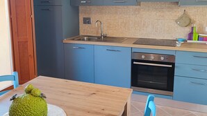 A modern kitchen with blue cabinets, a stainless steel sink, and a built-in oven. - Located in a quiet and pleasant setting a stone's throw from the sea (Toscana)