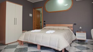 A bedroom with a bed, a wardrobe, a bedside table, and a mirror. - B&B Mauro Home bed&relax (Linguaglossa)