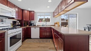 Eine moderne Küche mit Holzausstattung, Backofen und Geschirrspüler.