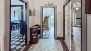 A hallway with a checkered floor, a bench, and a trash can labeled "IMPORTED OIL". - 4 bedroom nice home in Penvénan (Penvénan)