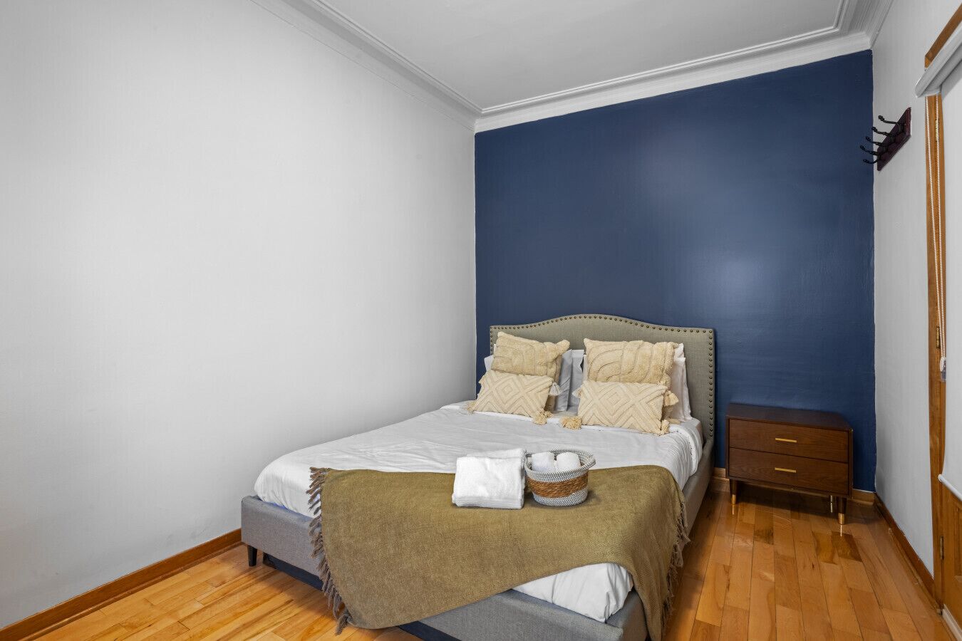 Un dormitorio con cama, mesita de noche y velador.