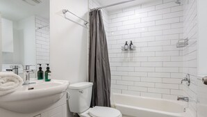 A bathroom with a white sink, toilet, and bathtub.