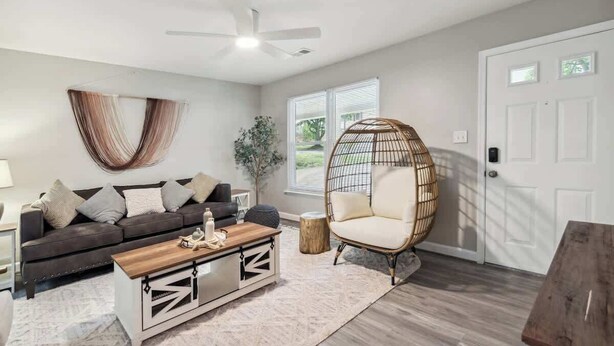 A living room with a sofa, coffee table, and a hanging chair.