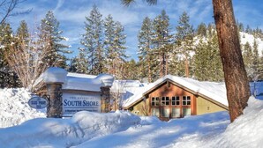 A lodge with a snow-covered roof, a sign reading "South Shore," and a wooden cabin in the background. - Charming 2-bedroom condo close to ski resort with WiFi in beautiful Zephyr Cove (Zephyr Cove)
