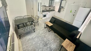 Un espacio habitable compacto con comedor, kitchenette y sofá.