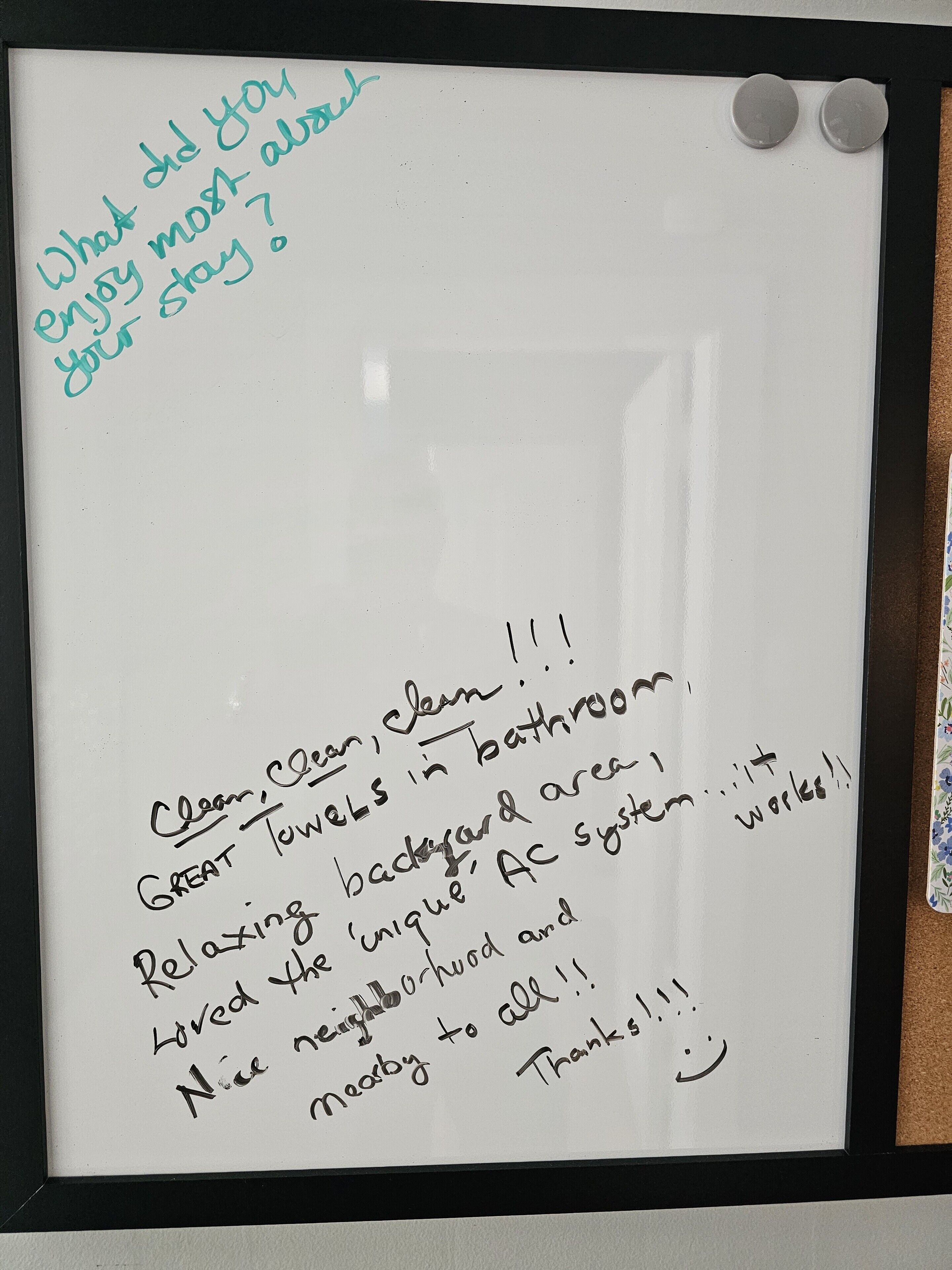 A handwritten note on a whiteboard with a black frame, expressing gratitude and mentioning cleanliness, towels, and a unique AC system.