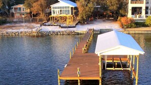 A waterfront property with wooden docks leading to a house and a covered area. - Bear Point Bay Front Beach House! Sleeps 12 (Orange Beach)