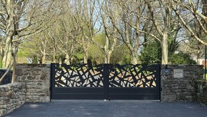 A gated entrance with a stone wall and a metal gate. - Romantic mini villa - heated pool and wooded park -Les Hauts de Locmiquel (Baden)