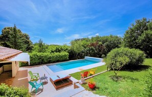 A backyard with a swimming pool, outdoor furniture, and a small garden area. - Nice home in Montélimar (Montélimar)