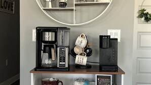 Eine Kaffeestation mit einer Wandtafel zum Thema Kaffee, einer Kaffeemaschine sowie verschiedenen Tassen und Teekannen.
