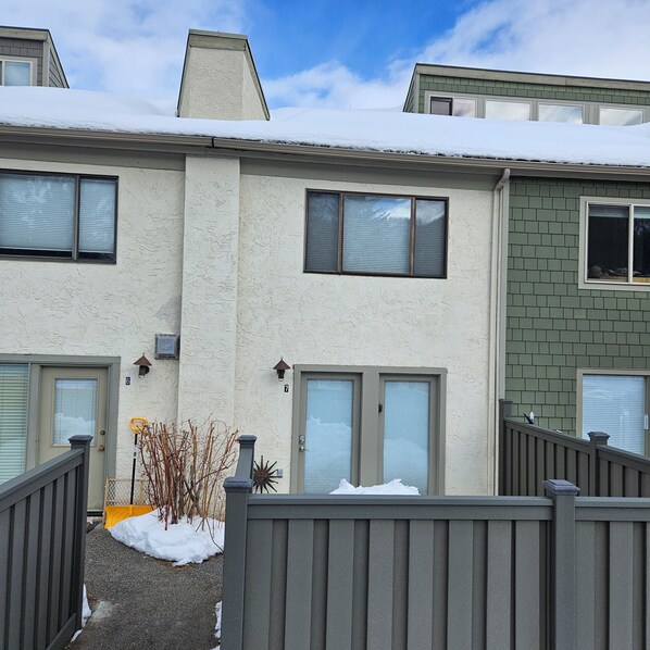 A row of townhouses with snow on the roofs and a clear sky.