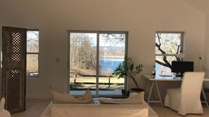 A modern bedroom with a large window, a desk with a computer, and a chair. - Hudson views! (Hudson)
