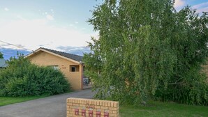 Pieni tiilestä rakennettu rakennus, jossa on yksi sisäänkäynti, postilaatikko ja numero 243 -kyltti.