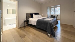 Ein Schlafzimmer mit Bett, Nachttisch und Fenster.