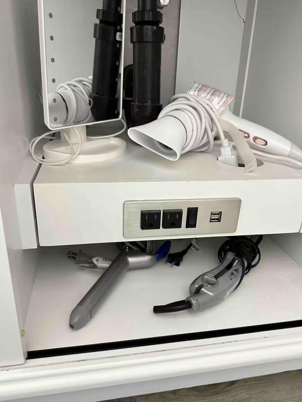 Un cuadro eléctrico blanco con tres enchufes y un puerto USB.