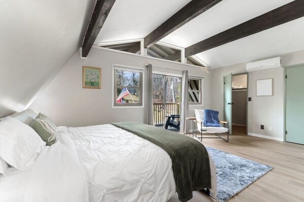 Een slaapkamer met een bed, een stoel, een raam en een deur.