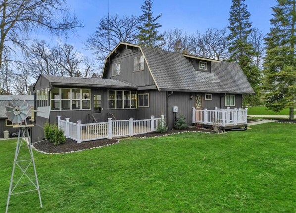 A two-story house with a grey exterior, white railings, and a well-maintained lawn. - 4BR Lake Geneva, Game Room, Sleeps 16 (Lake Geneva)