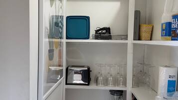 Una cocina con un tostador, una bandeja azul y una botella de jugo amarillo.
