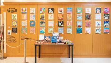 A wall displaying various artworks in a gallery setting.