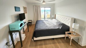A bedroom with a bed, a desk with a computer, a ceiling fan, and a window with curtains. - Myrtle Beach Resort (Myrtle Beach)