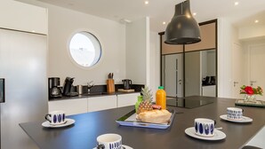 Une cuisine moderne dotée d’un îlot central, d’une fenêtre ronde et d’un four encastré.