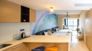 Une cuisine moderne dotée d’un îlot central, de tabourets de bar et d’une grande fenêtre qui laisse entrer la lumière naturelle.