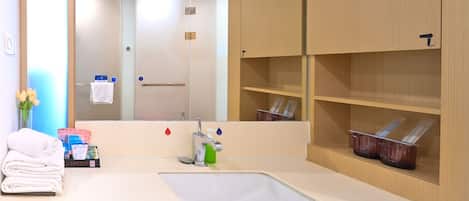 A modern bathroom with a large mirror, a sink, and shelves with toiletries.