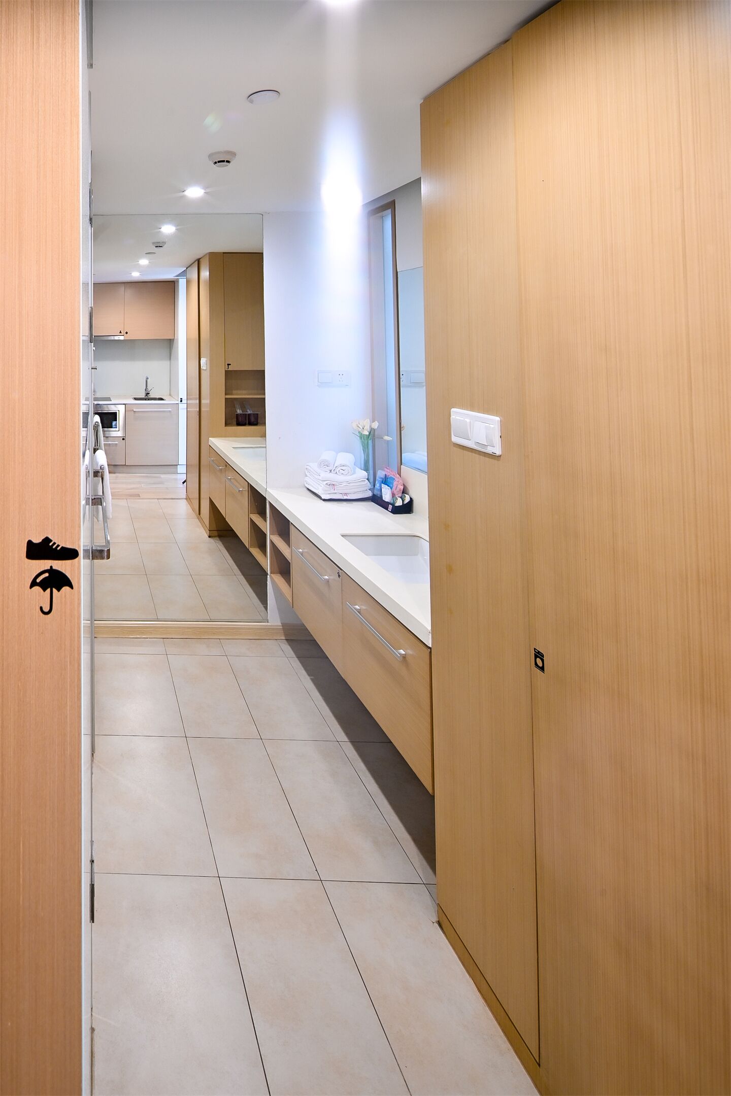 Una cocina moderna con armarios de madera, una encimera con un lavabo y un espejo sobre el lavabo.