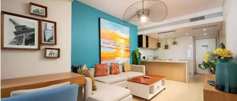 A modern living room with a sofa, coffee table, and artwork on the wall.