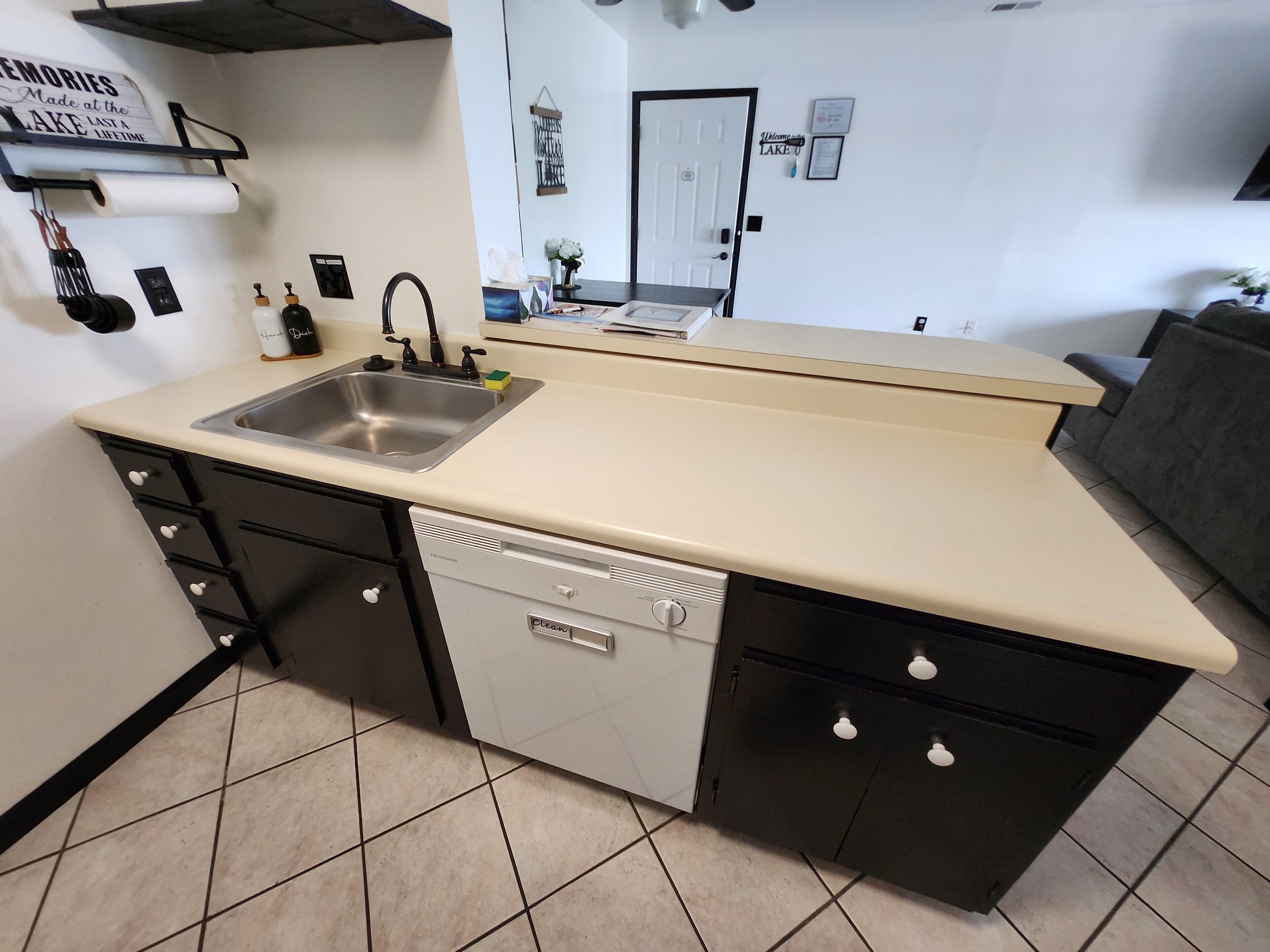 A compact kitchen with a sink, dishwasher, and a small countertop.
