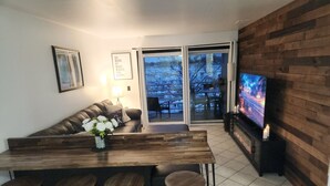Ein modernes Wohnzimmer mit einer Holztrennwand, einem Sofa und einem Fernseher.