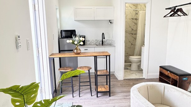 Un espacio habitable compacto con kitchenette, comedor y zona de estar.