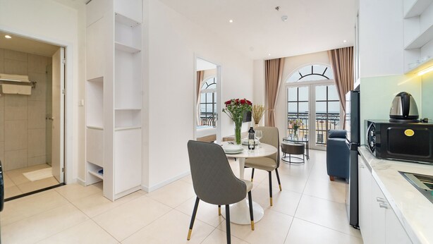 En moderne stue med spiseplads, et køkken og en balkon med udsigt.