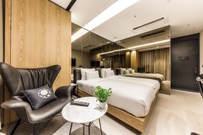 A modern hotel room with a large bed, a leather armchair, a small table, and a potted plant. - HOTEL CULLINAN (Seoul)