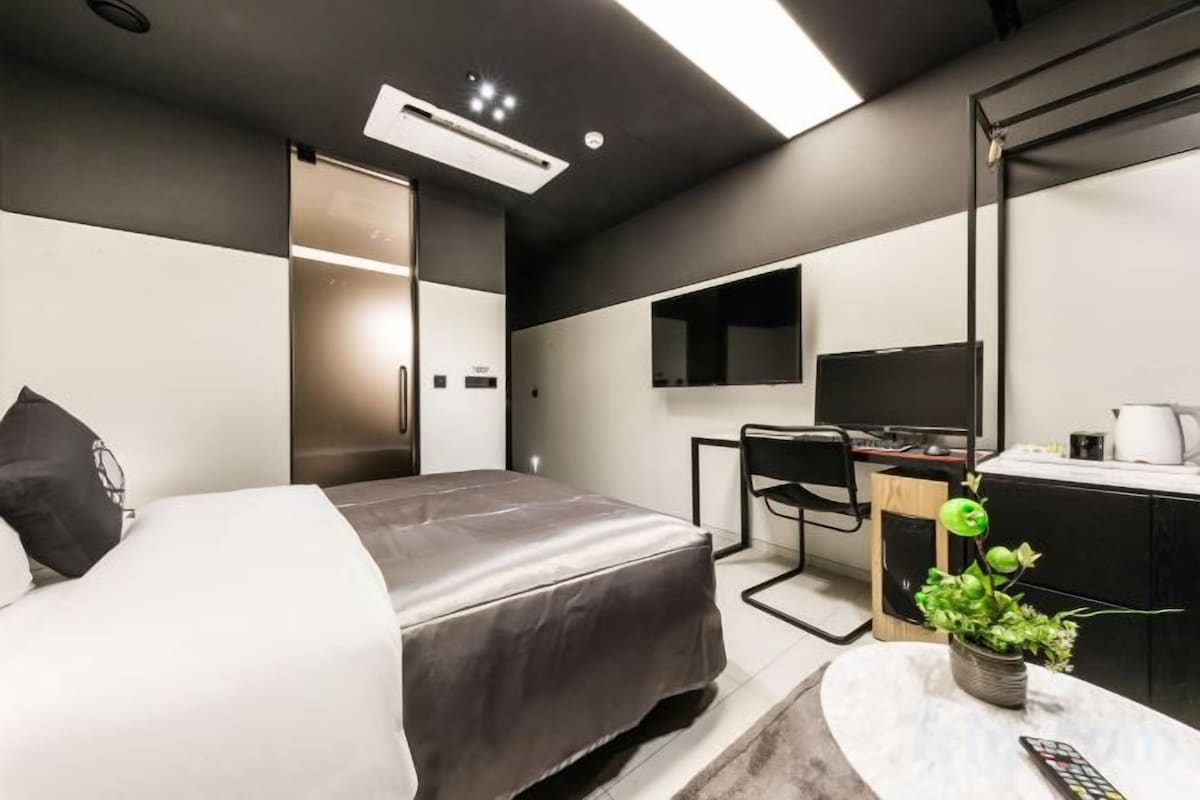 Une chambre d’hôtel moderne équipée d’un lit, d’un bureau et d’une télévision.