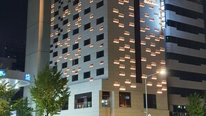Un hôtel au design moderne, caractérisé par une horloge imposante et des fenêtres illuminées.