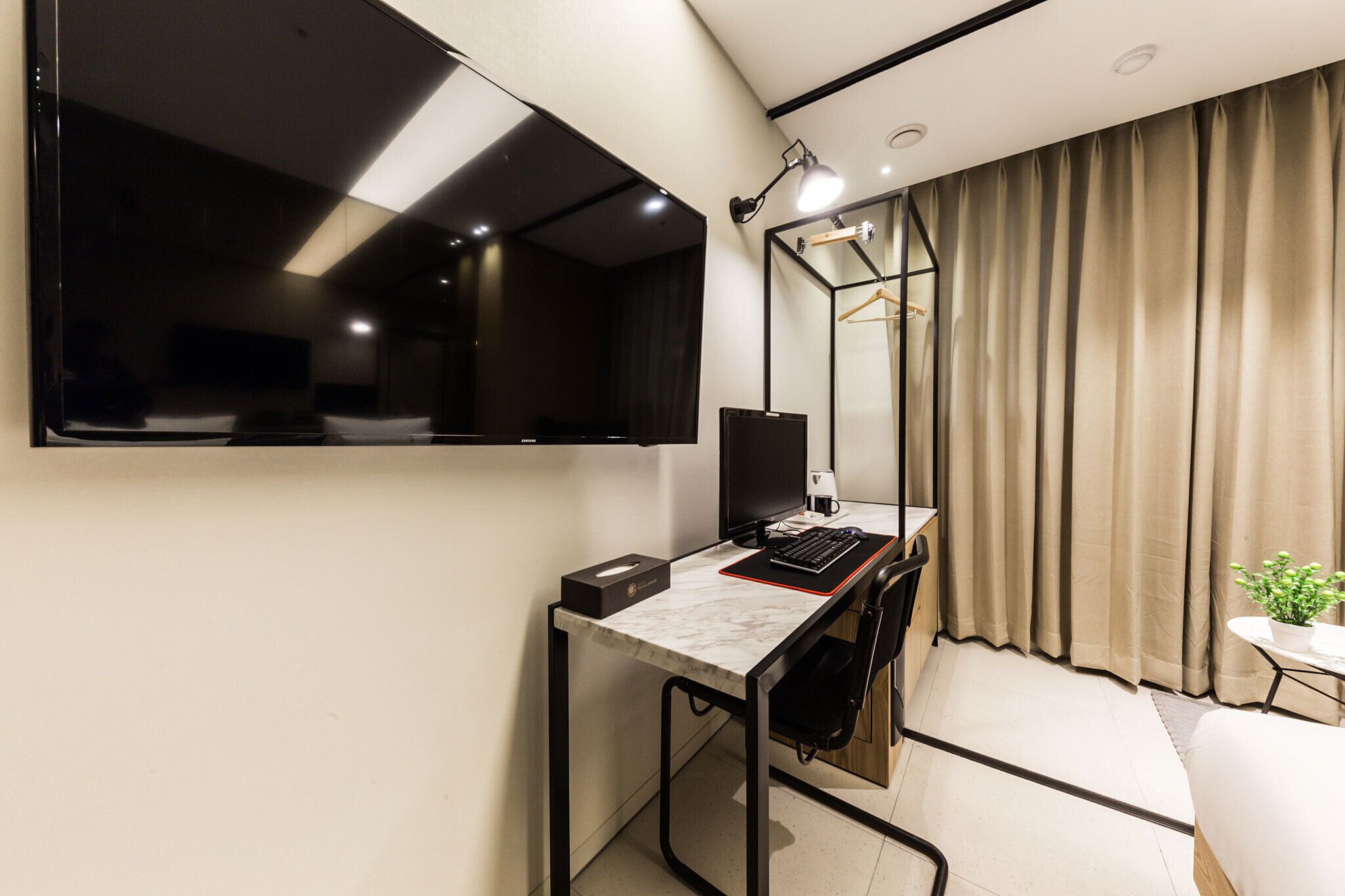 A modern office space with a desk, computer, and a large mirror.