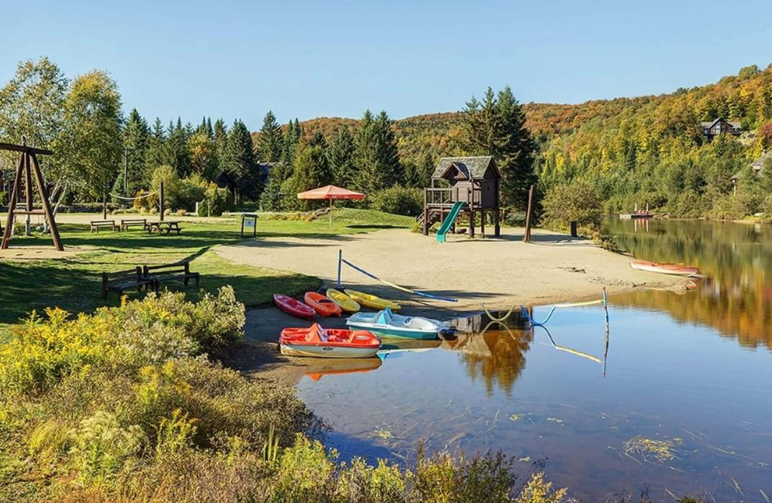 Un parc au bord du lac, doté d’une plage de sable, de tables de pique-nique, d’une aire de jeux et de kayaks.