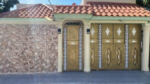 Un edificio con fachada de piedra, techo de tejas y una entrada decorativa con un gran puerta de madera.