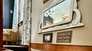 A staircase with a 'For Sale' sign, a framed mirror, and a motivational quote on the wall.