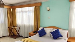 A hotel room with a bed, a bedside table with a phone, and a window with curtains. - Rwizi View Hotel Mbarara (Mbarara)
