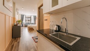 A modern kitchen with a marble countertop, stainless steel sink, and a built-in oven.