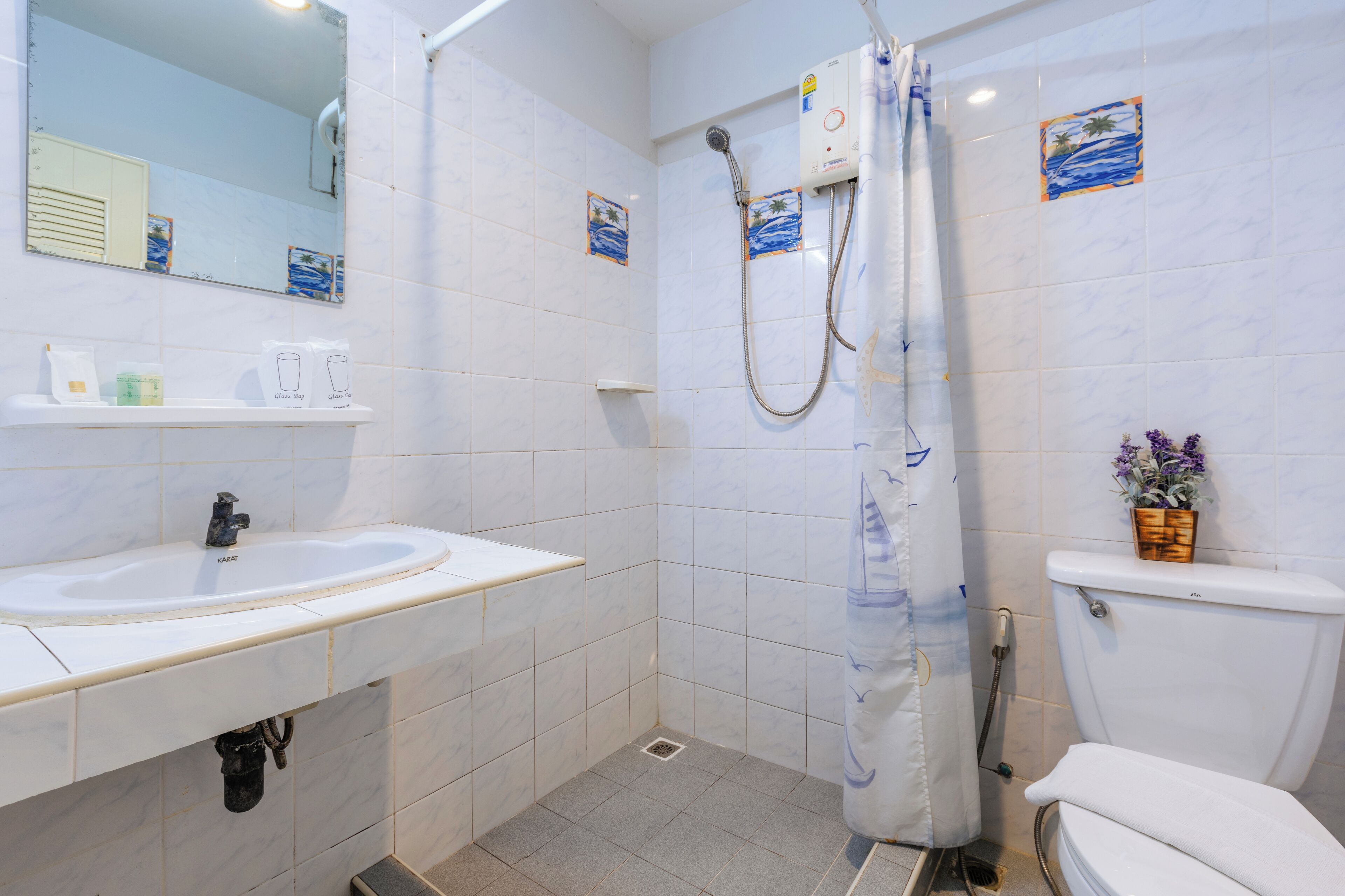 A bathroom with a sink, toilet, and shower.