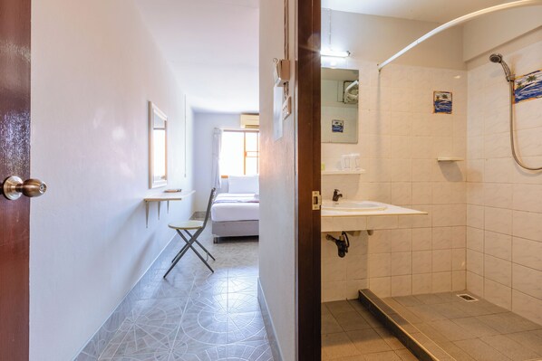 A hotel room with a bathroom featuring a shower, a sink, and a mirror. - Huahin Star Hotel (Hua Hin)