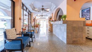 A hotel lobby with a reception desk, seating area with chairs and tables, a ceiling fan, and a large window. - Huahin Star Hotel (Hua Hin)