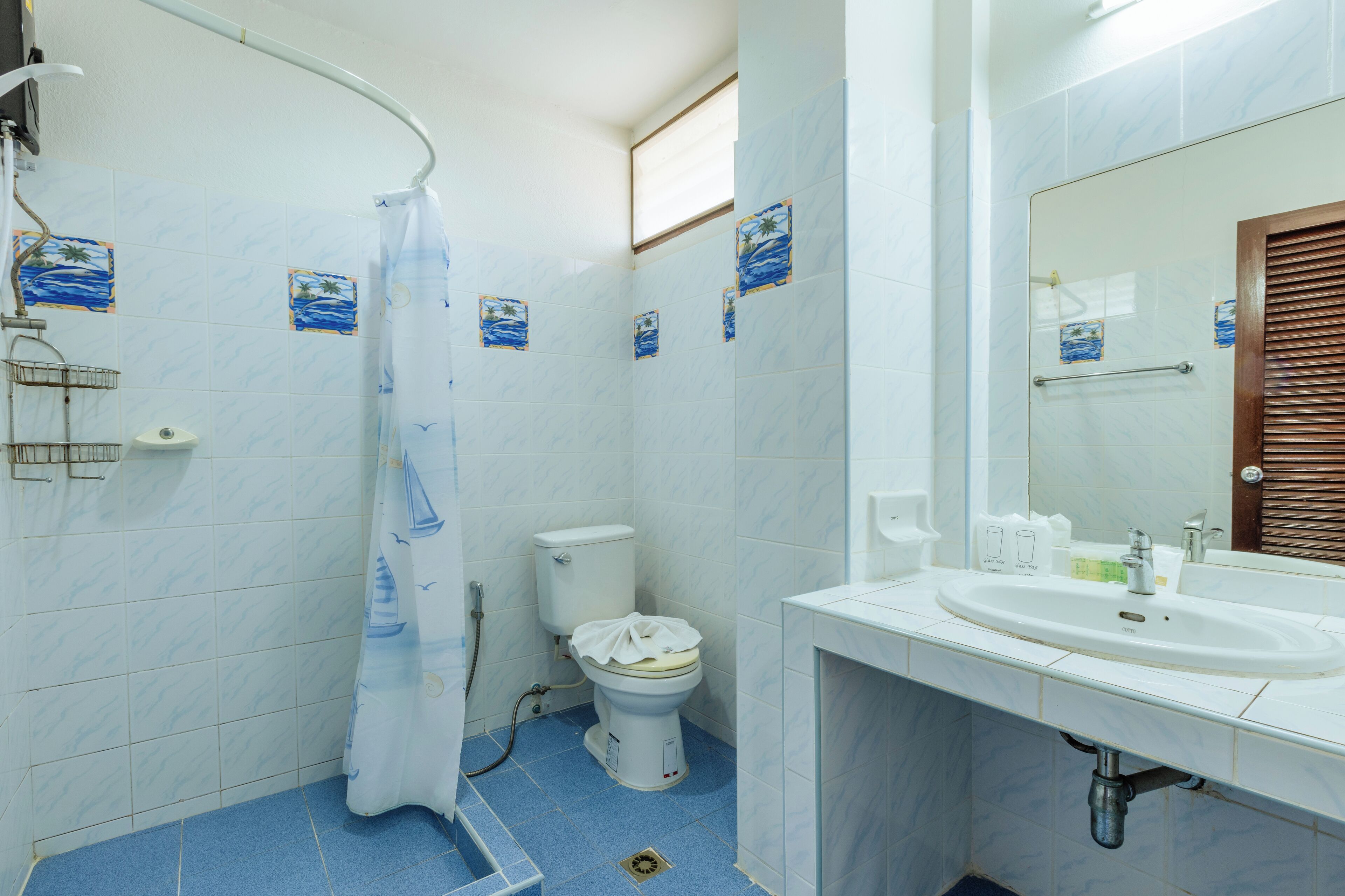 A bathroom with a shower, toilet, and sink.
