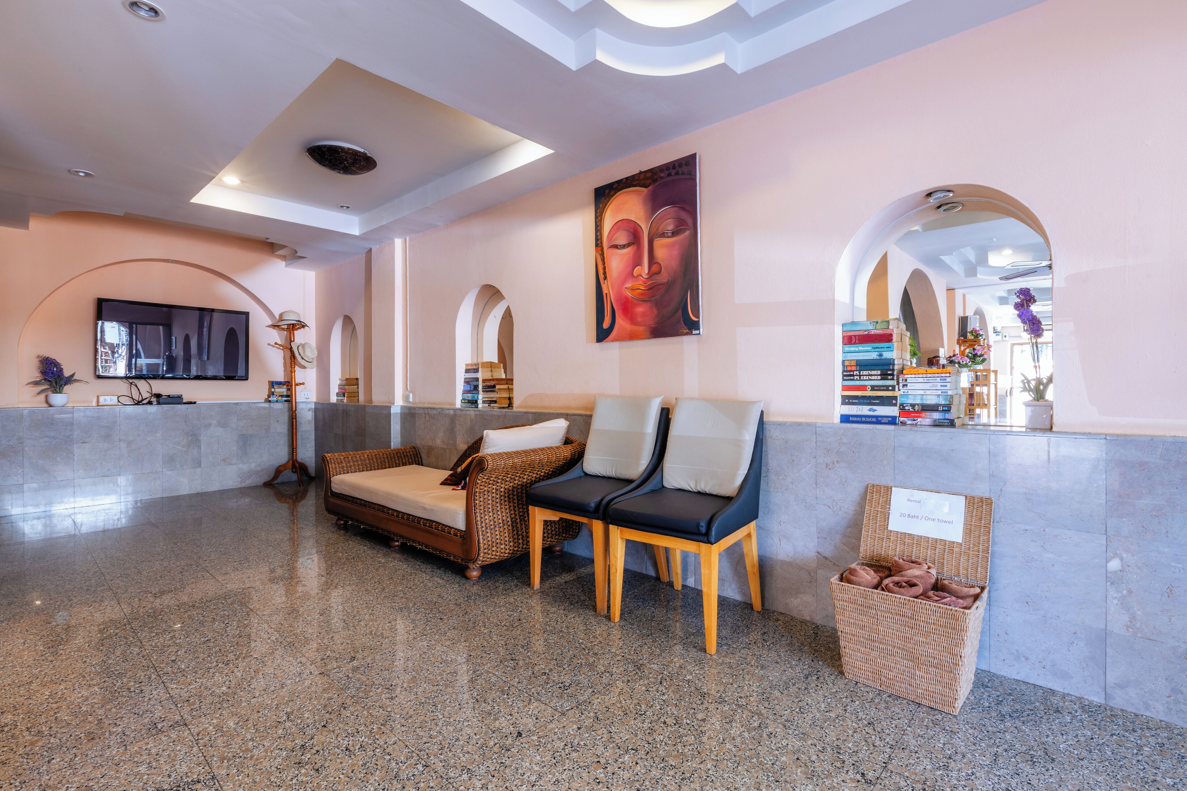 A lobby with a reception desk, seating area, and a wall-mounted television.